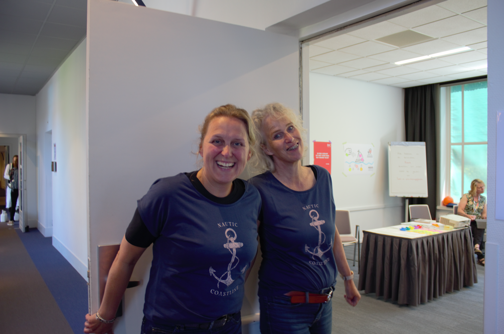 Two festival participants smile together in a workshop doorway.