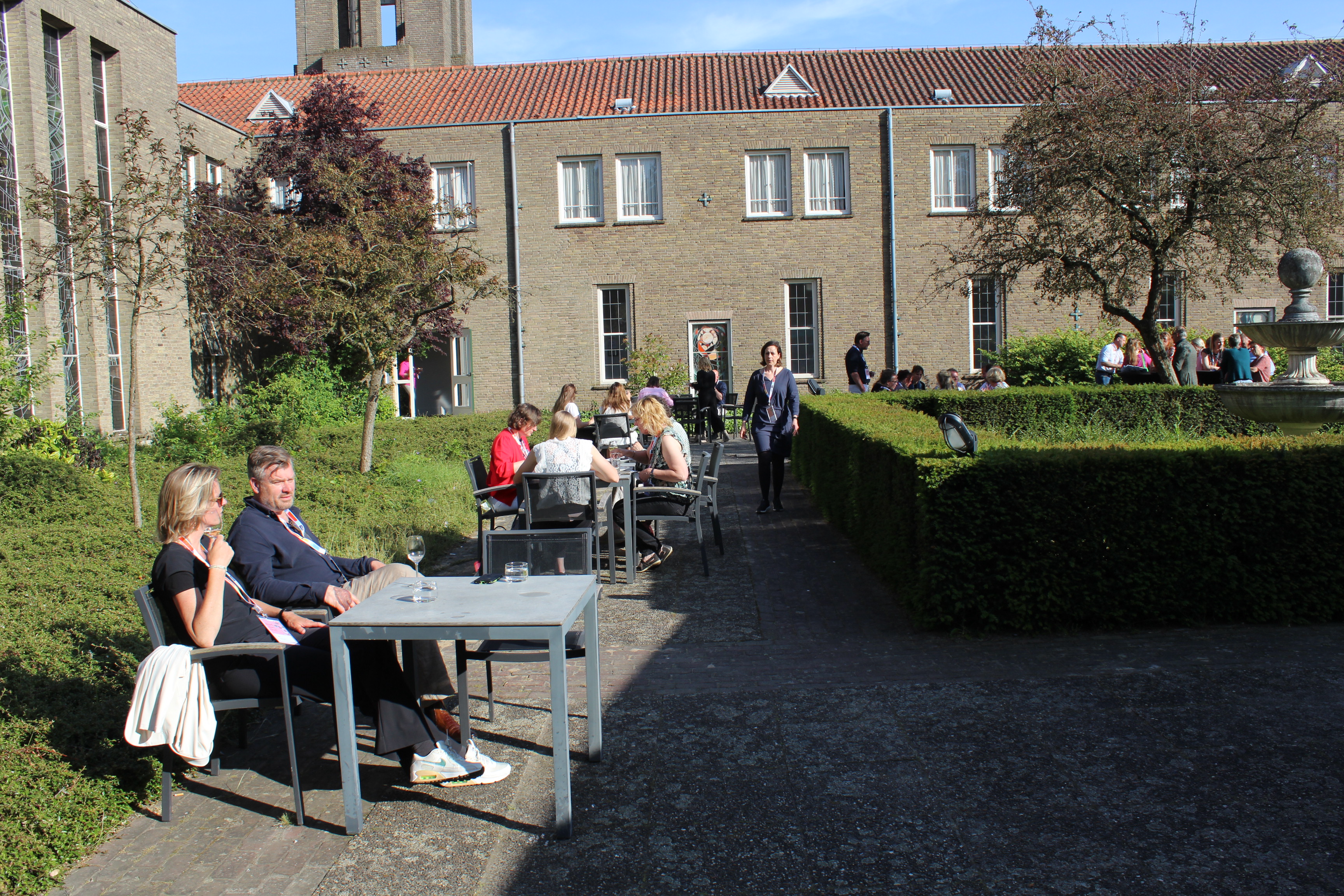 Festival guests gather in the sunlit courtyard of the Ljubljana venue.